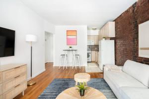 ein Wohnzimmer mit einem weißen Sofa und einer Ziegelwand in der Unterkunft 350-1A Gramercy New 1BR Sleeps4 Newly Furnished in New York