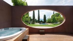 Baño circular con bañera y ventana redonda en Villa mit Pool, Whirlpool, Sauna und großem Privatgarten, en Caldaro