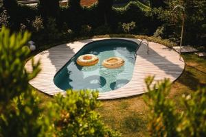 dos donuts sentados en un estanque en un patio trasero en Villa mit Pool, Whirlpool, Sauna und großem Privatgarten, en Caldaro