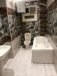 łazienka z toaletą, umywalką i wanną w obiekcie Jordan road Guest House w mieście Madaba