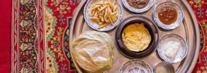 uma bandeja com diferentes pratos de comida numa mesa em Jordan road Guest House em Madaba