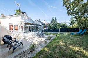 a yard with two chairs and a house at Le Saint tilleul - Maison - Jardin -10' Disneyland in Saint-Germain-sur-Morin