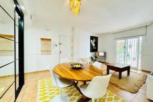 a dining room with a wooden table and white chairs at Logement vieux centre Marbella in Marbella