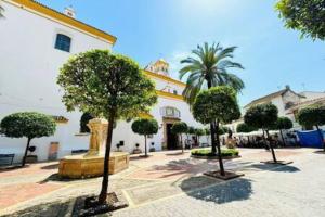 a building with a bunch of trees in front of it at Logement vieux centre Marbella in Marbella