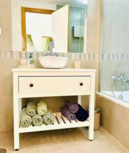 a bathroom with a sink and a vanity with towels at Logement vieux centre Marbella in Marbella +28 photos