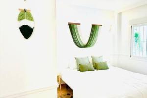 a white bedroom with a bed and a window at Logement vieux centre Marbella in Marbella
