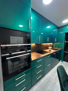 - une cuisine avec des placards verts et une cuisinière dans l'établissement APARTAMENTO CERCA AL MAR, à Benalmádena