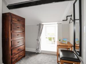 a room with a dresser and a desk and a window at Tan Yr Allt in Pwllheli