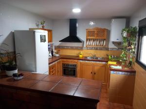 cocina con nevera blanca y armarios de madera en Casa San Francisco de Asís, en Córdoba
