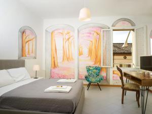 Dormitorio con cama, escritorio y pintura en Affittacamere di Andrea Bertolino San Lazzaro di Savena, en San Lazzaro di Savena