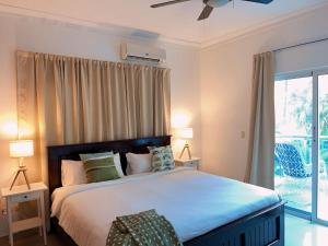 um quarto com uma cama com 2 candeeiros e uma janela em Apartamento a pasos de la playa em Punta Cana