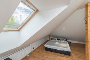 - une chambre mansardée avec un lit et une fenêtre dans l'établissement Central Studio Apartments by Hostlovers, à Kaunas