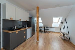 una cucina con armadietti neri e palo di legno di Central Studio Apartments by Hostlovers a Kaunas