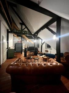 ein Wohnzimmer mit einem braunen Ledersofa in einem Zimmer in der Unterkunft Luxurious loft on 2 floors in Köln