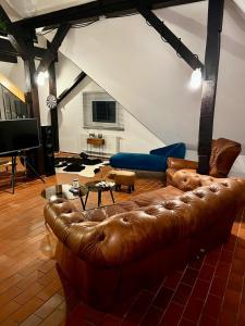 sala de estar con sofá de cuero marrón y TV en Luxurious loft on 2 floors, en Colonia