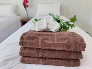 a pile of towels on a bed with a bouquet of flowers at Ikebukuro 2bedroom 704 in Tokyo