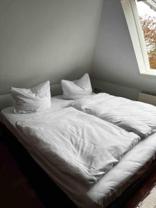 ein unmaskiertes Bett in einem Zimmer mit Fenster in der Unterkunft Luxurious loft on 2 floors in Köln