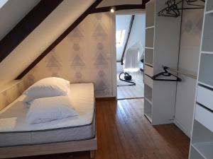 um quarto com uma cama num sótão em Maison idéalement située em Pordic