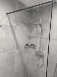 a shower with a shower head in a bathroom at Pokoje gościnne U Bosmana in Dźwirzyno