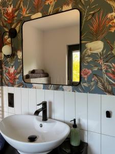 a bathroom with a white sink and a mirror at Sielskie Chatki in Sandomierz