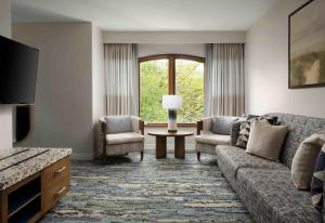 een woonkamer met een bank en 2 stoelen bij El Colibri Hotel & Spa in Cambria