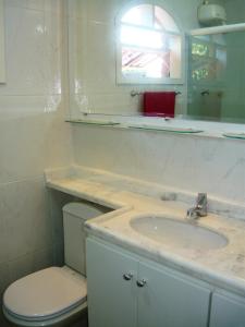 a bathroom with a sink and a toilet and a mirror at Sitio do Popay in Rio de Janeiro
