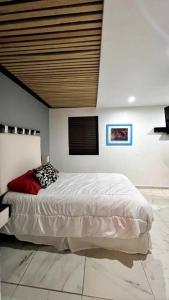 ein Schlafzimmer mit einem großen Bett und einer Holzdecke in der Unterkunft Maranello - Exclusive Suite Guadalupe Inn in Mexiko-Stadt