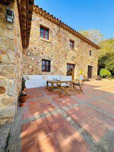 a stone building with a picnic table in front of it at B&B La Vista Brava in Platja d'Aro