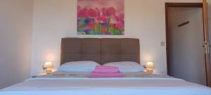 een bed met een roze handdoek erop bij Apartments & rooms Mila in Banjol