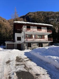 a building in the snow in front of a mountain at Appartamento in villa a Champoluc Ayas in Brusson