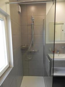 une douche avec une porte en verre à côté d'un lavabo dans l'établissement Ferienhaus für 3 Personen in Burscheid, Nordrhein-Westfalen, à Burscheid