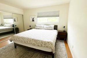 a bedroom with a large bed and a mirror at Large house and yard close to La Jolla, UCSD, UTC Mall! in San Diego