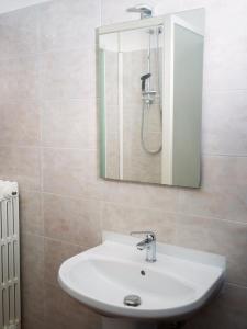 La salle de bains est pourvue d'un lavabo blanc et d'un miroir. dans l'établissement Affittacamere di Andrea Bertolino San Lazzaro di Savena, à San Lazzaro di Savena