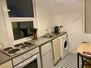 cocina con fregadero y lavavajillas en Thornton Heath Studios - Sleeps 2, en Thornton Heath