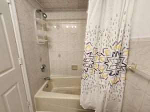 een badkamer met een douche, een bad en een douchegordijn bij Close to NYC - 3BD Spacious and Secluded apt in Jersey City
