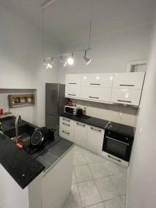 een keuken met witte kasten en een zwart aanrecht bij Private Spacious Apartment in Athene