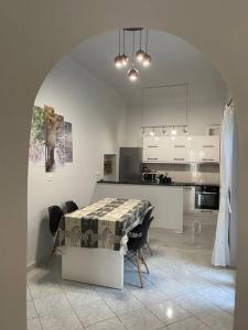 uma cozinha com mesa e cadeiras e uma cozinha com armários brancos em Private Spacious Apartment em Atenas