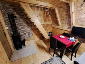 an attic room with a table and a wood stove at Vikendica Šumski Dragulj in Bajina Bašta