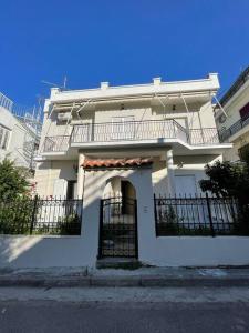 a white house with a balcony on the side of it at Private Spacious Apartment in Athens