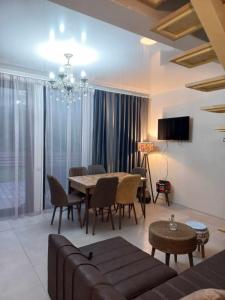 - un salon avec une table, des chaises et un lustre dans l'établissement RESORT WEEKEND BoRJOMI, à Bordjomi