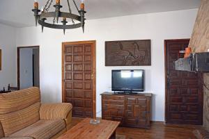 - un salon avec une télévision et un canapé dans l'établissement La Posada de Redios, à Cañaveral