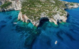 an island in the ocean with two boats in the water at Villa Roxa Montuoso in Agios Leon