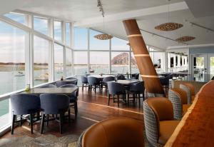 モロ・ベイにあるInn at Morro Bayのテーブルと椅子が備わるレストランで、水辺の景色を望めます。