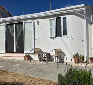 een terras met stoelen en een tafel voor een huis bij La Peñita - sunny guesthouse with private pool and garden in Salobreña