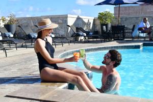 um homem e uma mulher sentados numa piscina com uma bebida em Hotel Atlante Plaza no Recife