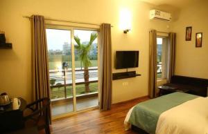 a bedroom with a bed and a large window with a view at Janardana Resorts in Vrindāvan