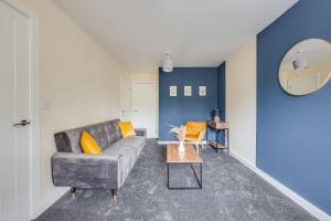 uma sala de estar com um sofá e uma mesa em 3 Bed House - Contractors, Relocators & Visitors, Coffee Machine & Free Parking em Bedford