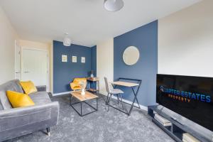 uma sala de estar com um sofá e uma televisão em 3 Bed House - Contractors, Relocators & Visitors, Coffee Machine & Free Parking em Bedford