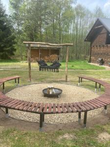 a bench in a park with a fire pit at Agroturystyka Oaza Ciszy i Spokoju in Międzychód