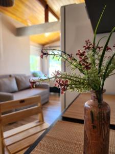 a vase with flowers on a table in a living room at Casamar Lofts Praia dos Anjos 03 in Arraial do Cabo